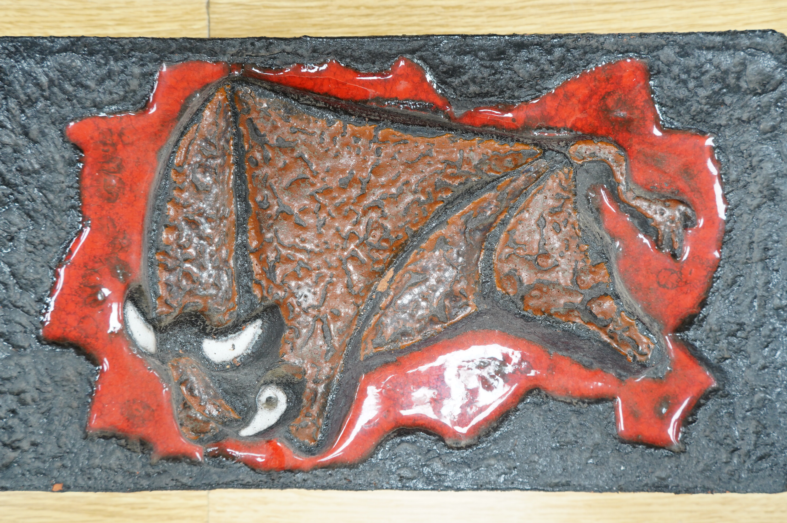 A West German terracotta wall plaque “The Bull”, 41cm wide, 23cm high. Condition - fair